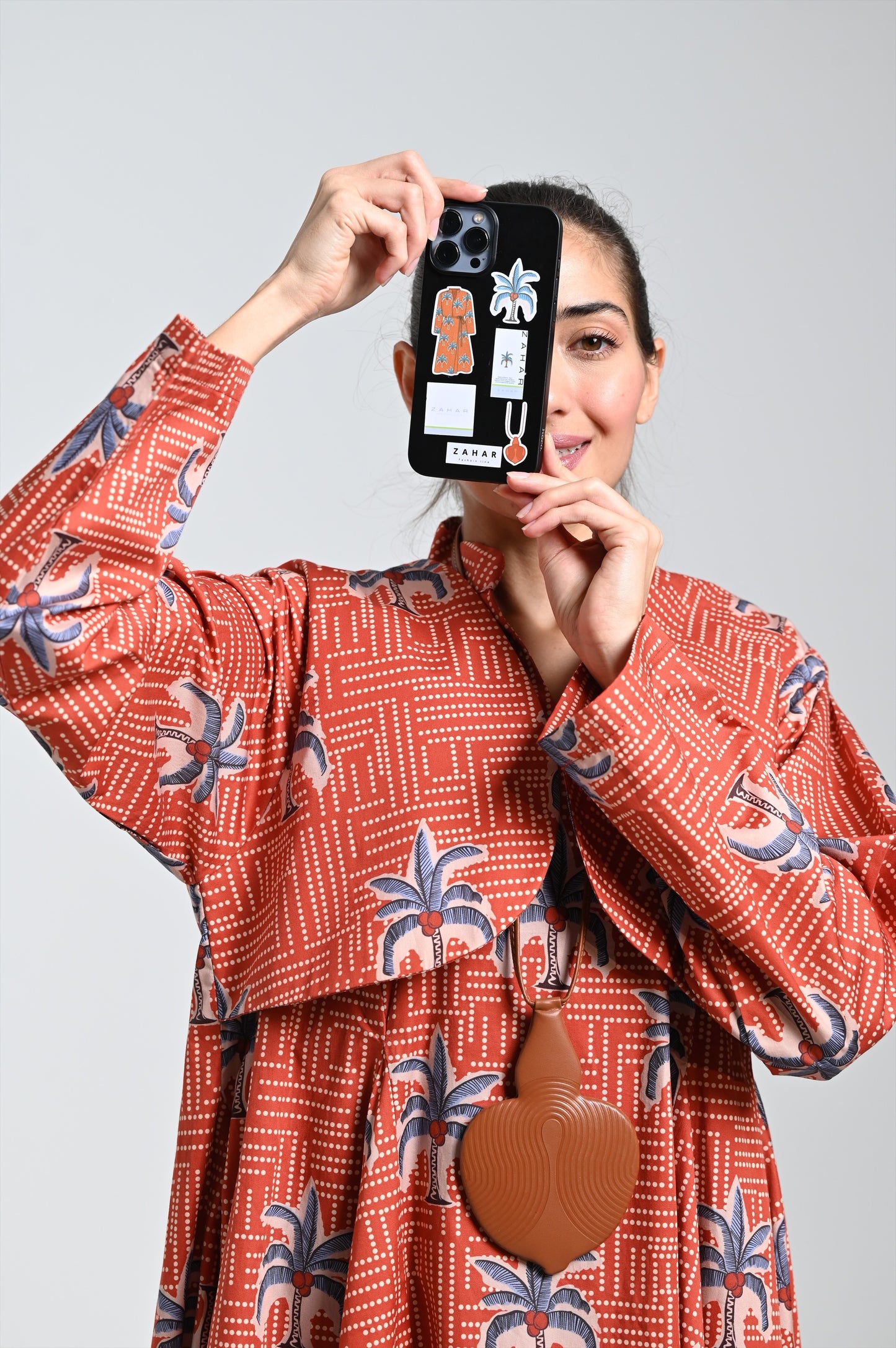 فستان برونزي بطبعة نخيل وقلادة جلدية