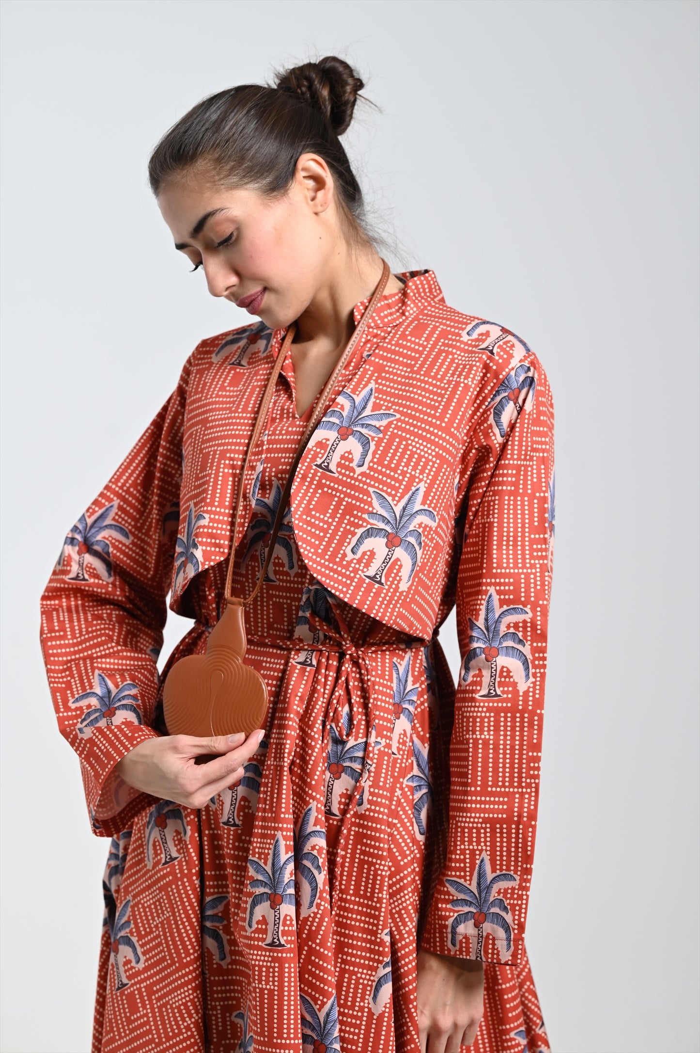 فستان برونزي بطبعة نخيل وقلادة جلدية